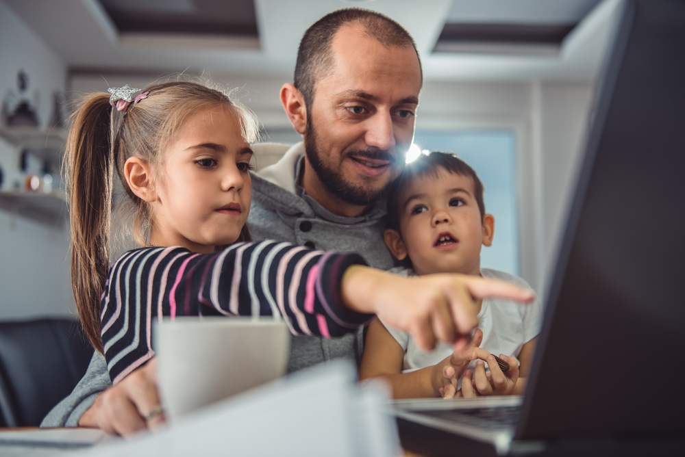 Father with children looking at computer